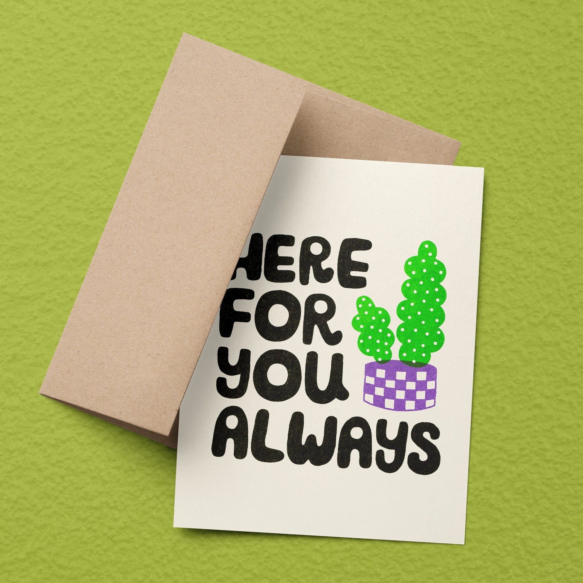 A risograph printed greeting card with kraft envelope, sits on a lime green background.
